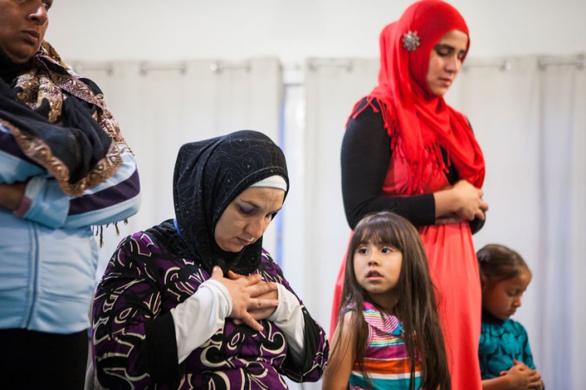 Naima (née Nancy) Carr, 29, seated in black hijab, and Jamila (née Daniela) Ortiz, 24, standing in red hijab, pray at the Masjid Al-Islam located in the Las Playas neighborhood of Tijuana. 'A lot of my family has stopped talking to me because of my religion,' said Carr who married an American convert but chose to follow Islam of her own volition after witnessing his dedication to ritual during Ramadan two years ago. - 