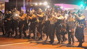 Law enforcement officers watch on during a protest on West Florissant Avenue in Ferguson, Mo., on Aug. 18, 2014. (credit: Michael B. Thomas/AFP/Getty Images)