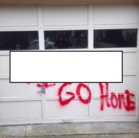 Montgomery County police edited this photo to cover a racial slur spray-painted onto the garage door of a home in Chevy Chase. (Montgomery County Police Department)