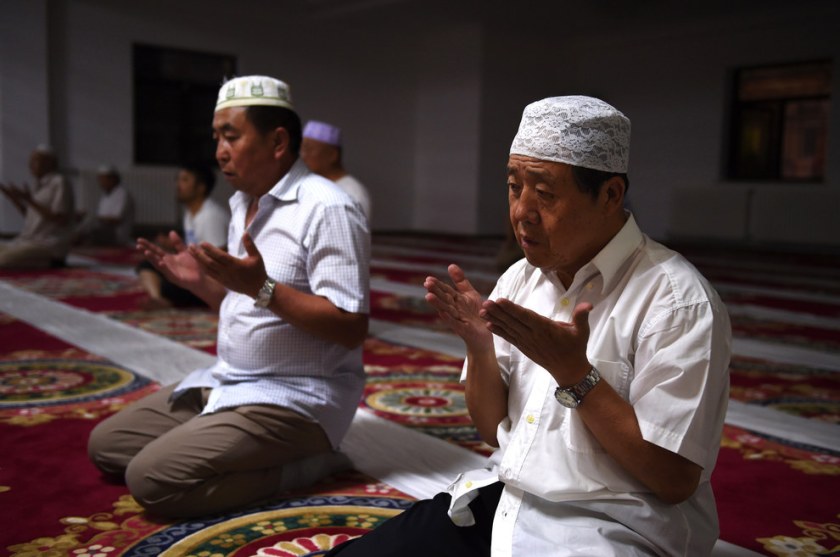 Muslims pray after breaking their fast on the first day of Ramadan, the muslim holy month, at a mosque in Beijing. China has banned civil servants, students and teachers in its mainly Muslim Xinjiang region from fasting during Ramadan and ordered restaurants to stay open. Greg Baker / AFP / Getty Images